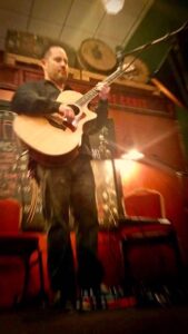Jeremiah Williams performing acoustic guitar at the Shawnee Tap Room