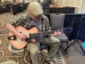 Jeremiah Williams trying an acoustic guitar at the Artisan Guitar Show