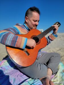 Jeremiah Williams playing acoustic guitar outdoors in Cape May